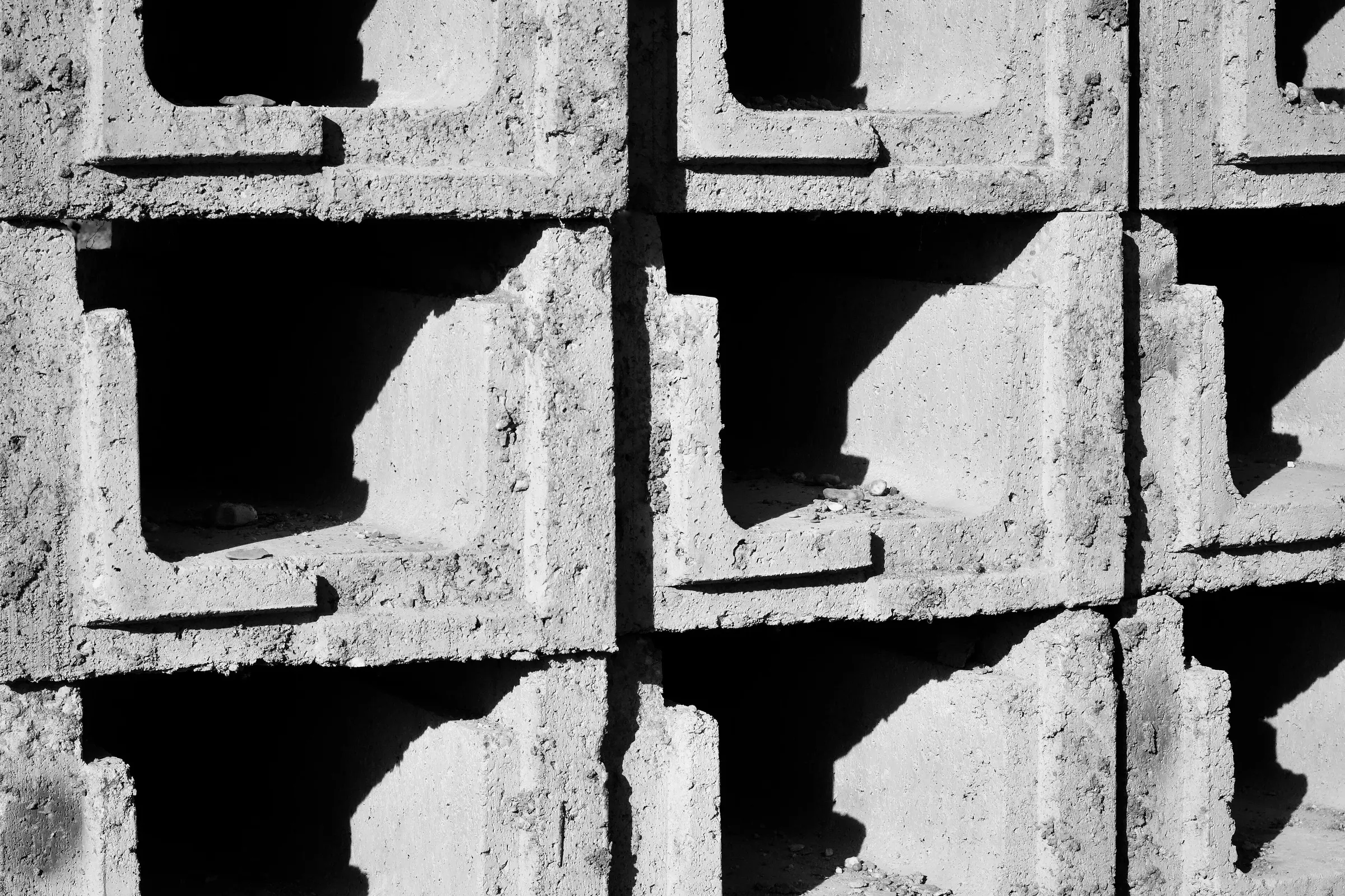 Close-up of stacked hollow cement blocks showing their texture, webs and edges