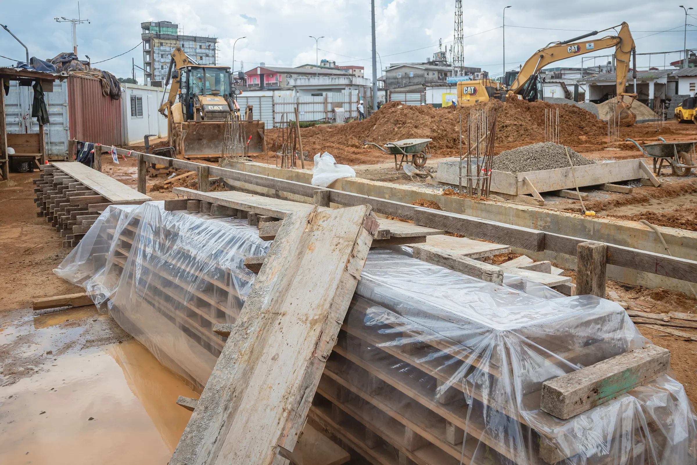 Foundation works for an apartment building, with formwork, steel and excavators on site