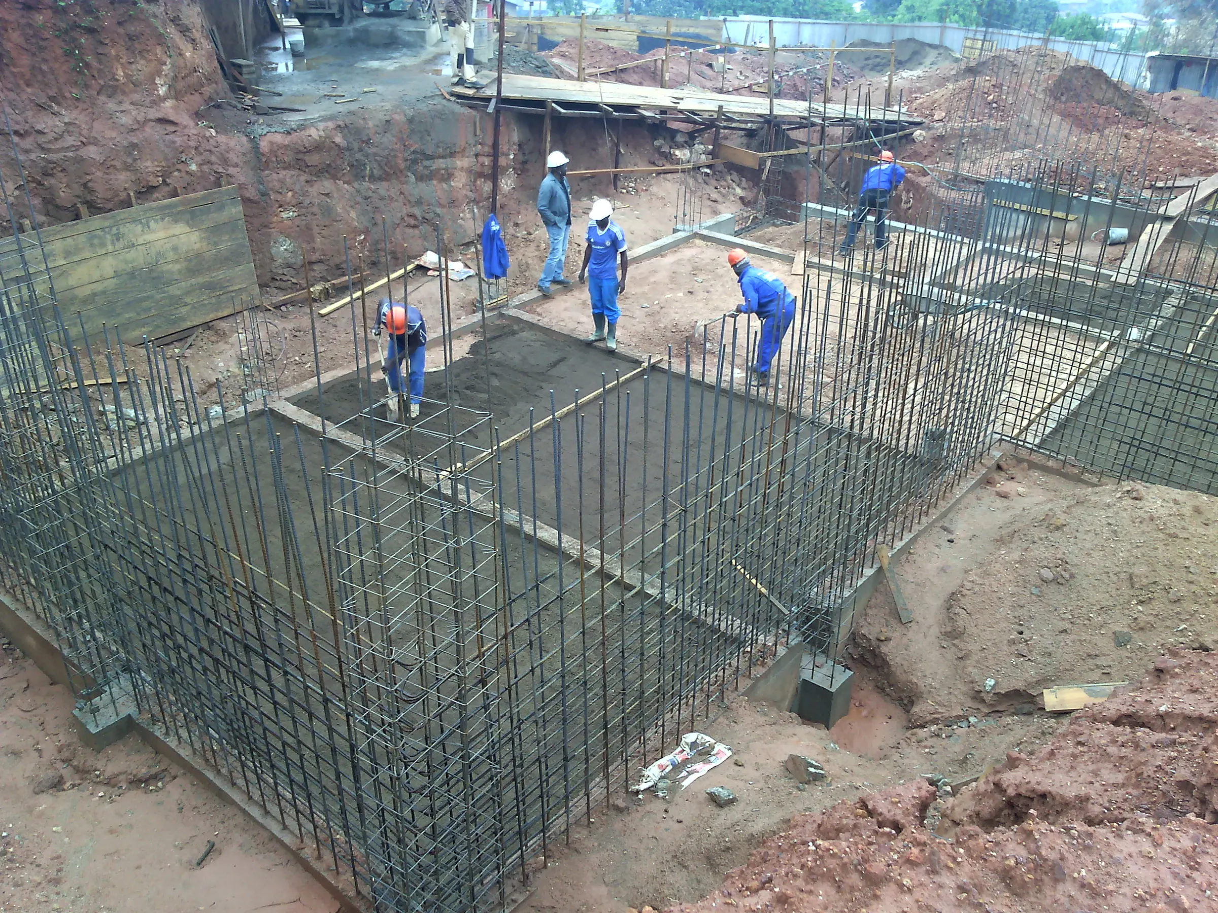 Workers fixing steel reinforcement for a foundation raft