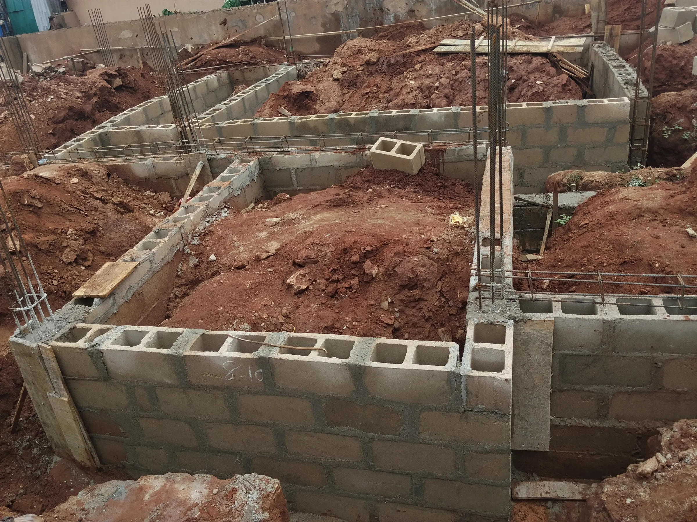 Cement-block foundation walls with steel reinforcement bars rising from the corners