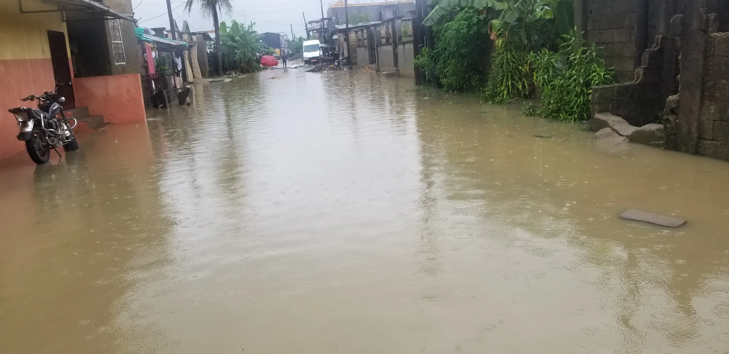 Flooded street between houses in Bonamoussadi, Douala, after heavy rain
