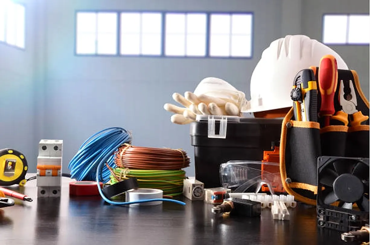 Electrical installation tools and materials: cable reels, circuit breaker, safety helmet and tool belt