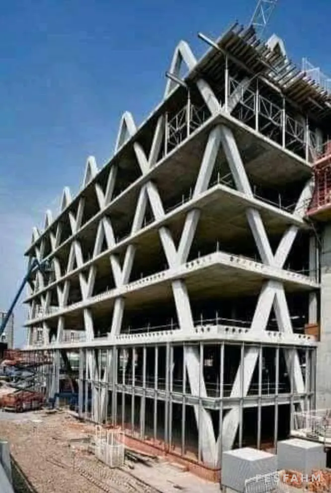 Multi-storey concrete frame under construction with V-shaped diagonal columns around the edge of each floor